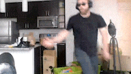 a man wearing headphones and sunglasses is dancing in a kitchen