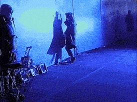 a group of people standing in front of a wall with blue lights behind them