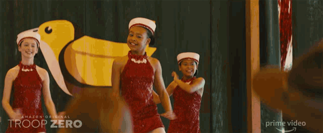 a advertisement for troop zero shows a couple of girls standing on paint cans