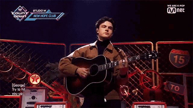 a man playing a guitar in front of a sign that says 15 on it