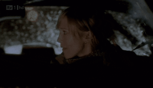 a woman sitting in a car with itv 1 hd on the bottom right