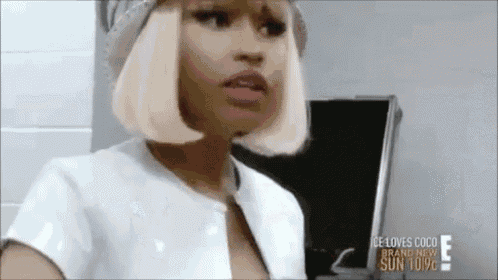 a woman with blonde hair and red lips is wearing a white shirt and a hat .