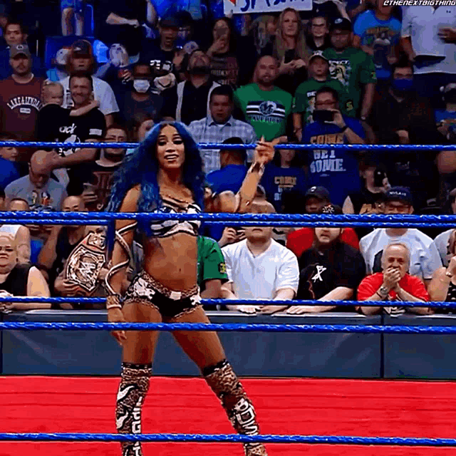 a woman in a wrestling ring is wearing a championship belt