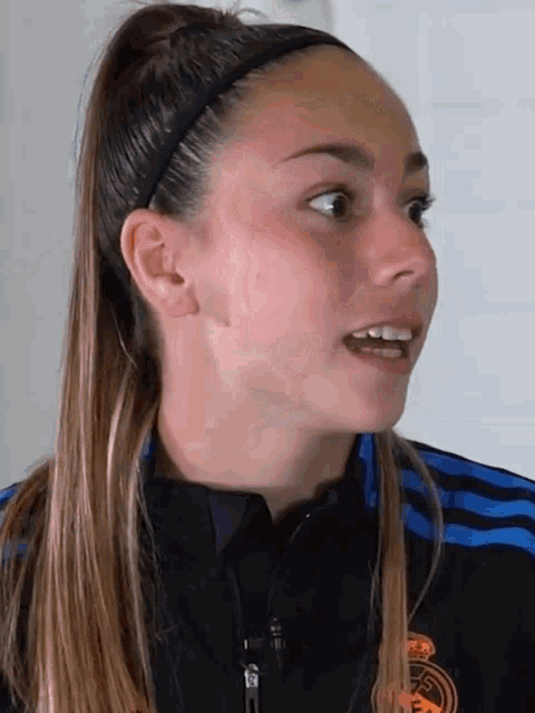 a close up of a woman 's face with a real madrid shirt on