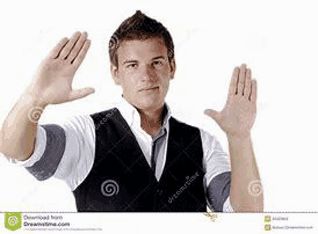 a young man in a black vest and white shirt is holding his hands up in the air .