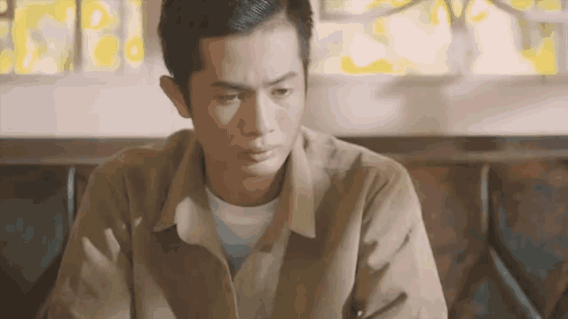 a man in a brown shirt is looking down