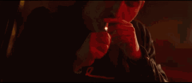 a man is lighting a cigarette with a lighter