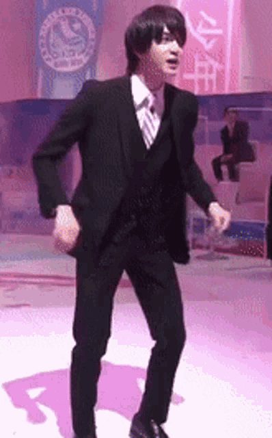 a man in a suit and tie is dancing in front of a sign that says ' youth ' on it