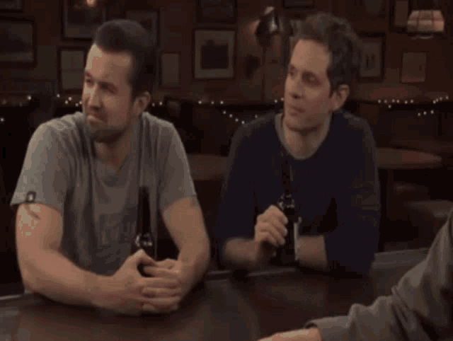 a group of people are sitting at a bar and one of them is wearing a shirt that says ' army ' on it