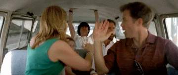 a group of people are sitting in a van and giving each other high fives .