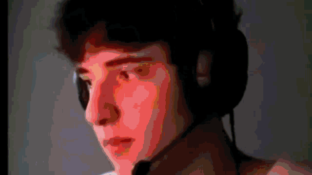 a man wearing headphones and a microphone is looking at something