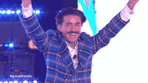 a man in a blue plaid jacket with his arms in the air and the words grandefratello on the bottom
