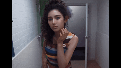 a woman in a striped dress is standing in a bathroom