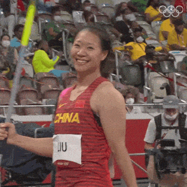a woman wearing a china jersey holds a baton