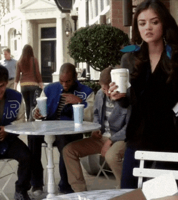a man in a blue jacket with the letter r on it sits at a table