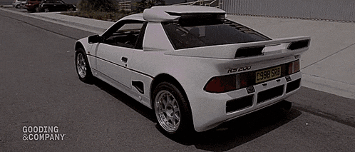 a white sports car with a license plate that says c998 skb