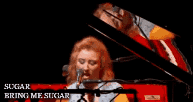 a woman singing into a microphone while playing a piano with the words sugar bring me sugar written on the bottom