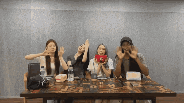 a group of people are sitting at a table with a bottle of water on it