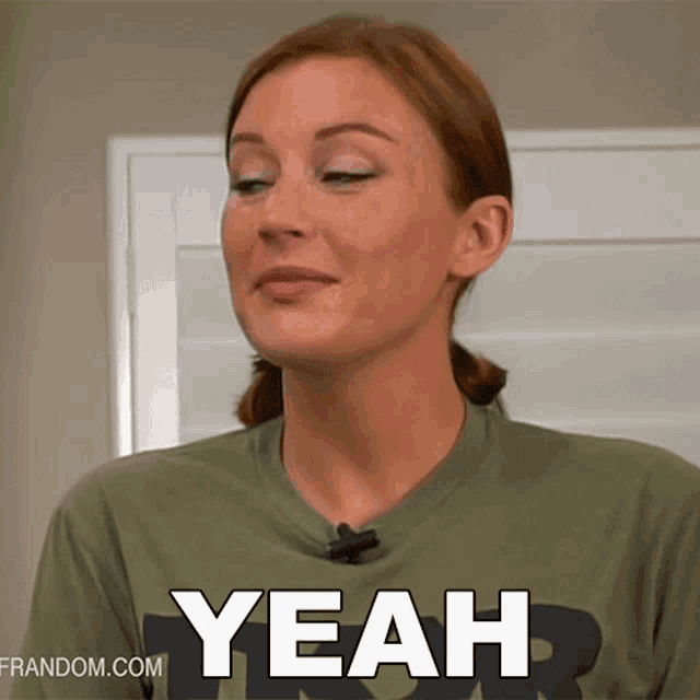 a woman wearing a green shirt with the word yeah on it