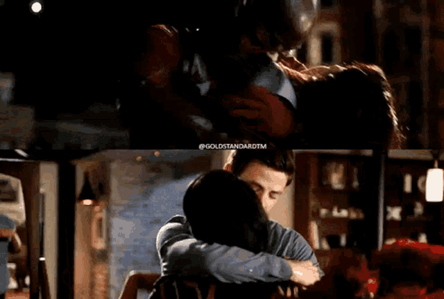a man and a woman hugging in a room with the words goldstandardtm on the bottom right