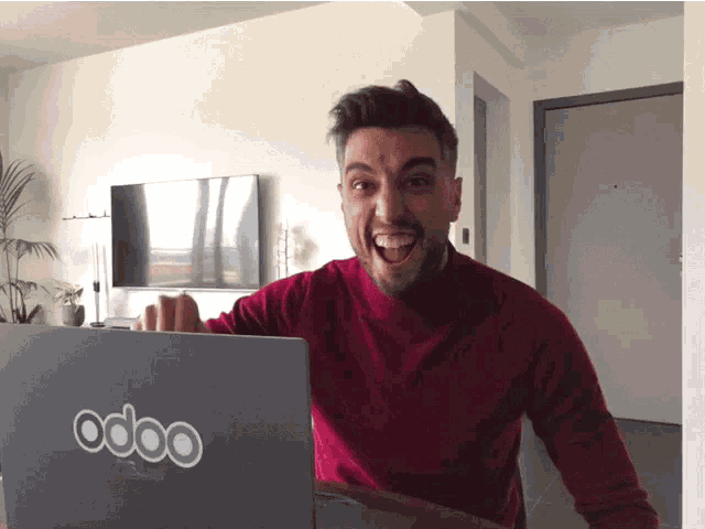 a man is sitting in front of a laptop that says odoo on it