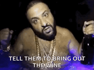 a shirtless man is holding a bottle of wine and a bottle of beer .