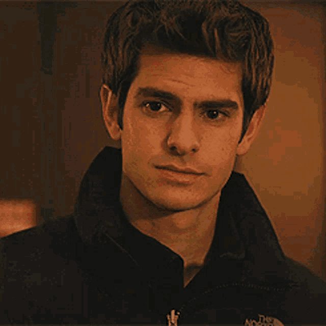 a young man wearing a black jacket with the north face on it