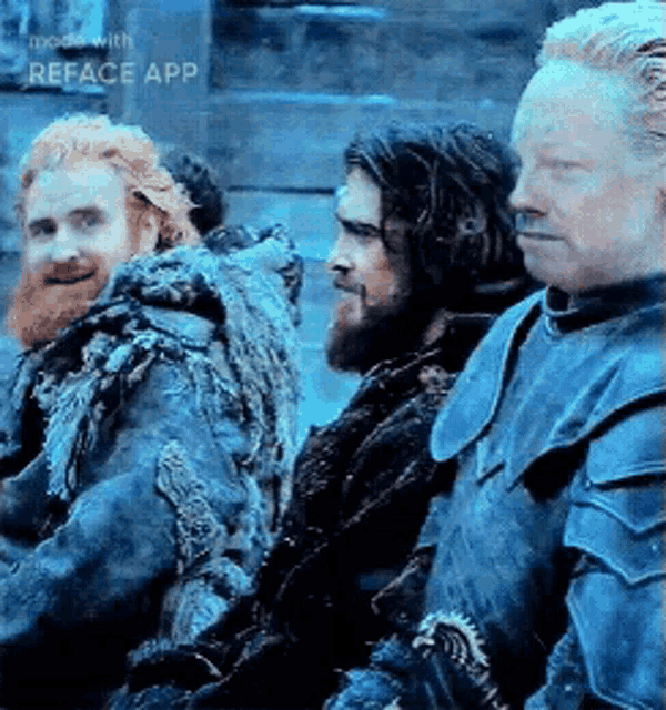 a group of men are standing next to each other and one of them is wearing a blue armor .