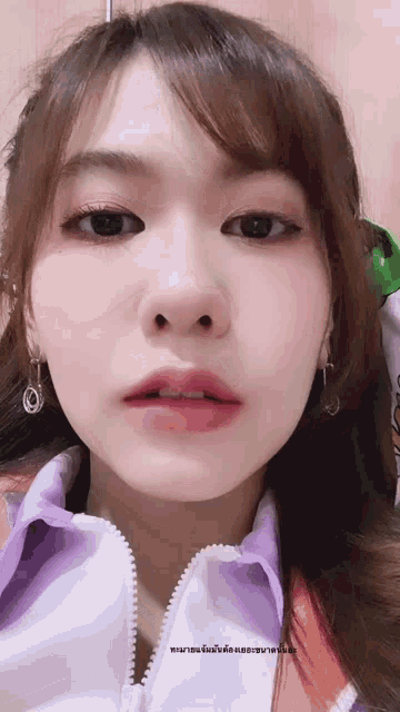 a close up of a woman 's face with a foreign language written on the bottom