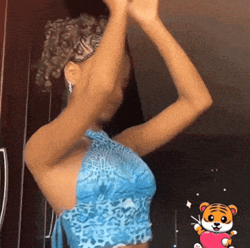 a woman in a blue top with a cartoon tiger holding a heart