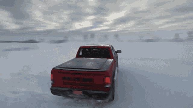 a red dodge ram truck is driving through a snowy field
