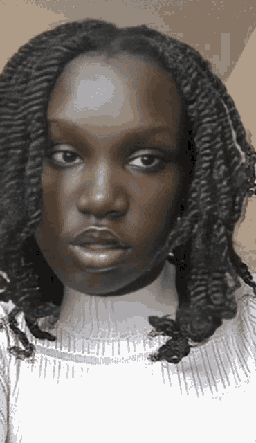a close up of a woman 's face with braids on her hair