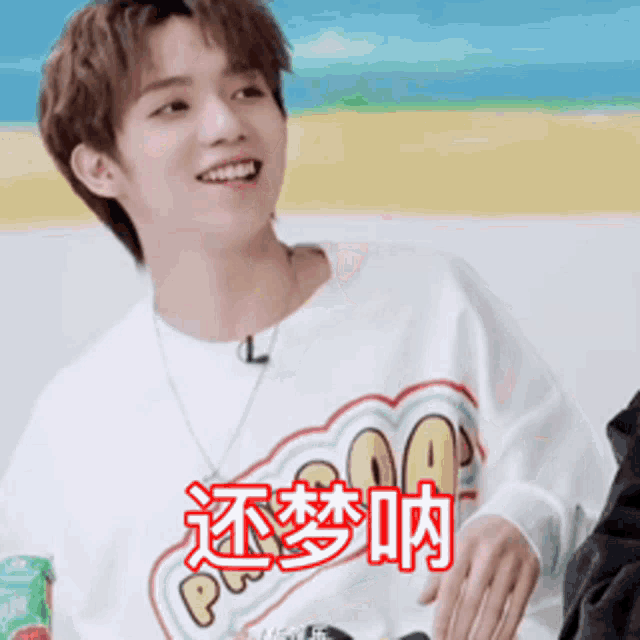 a young man wearing a white shirt with chinese writing on it .