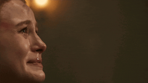 a woman is crying in front of a mask with the words because you were here below her