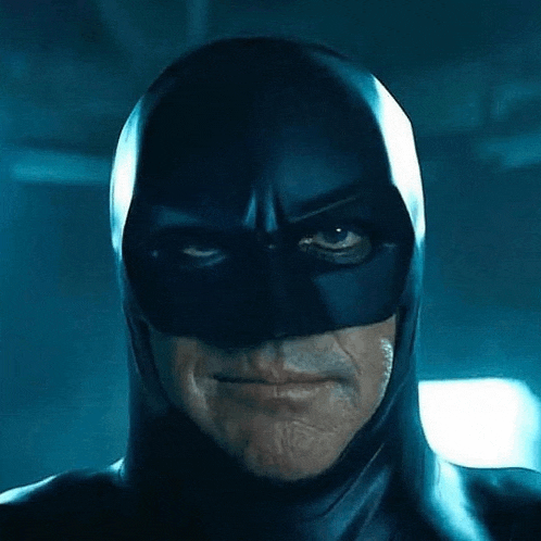 a close up of a man wearing a batman costume and mask