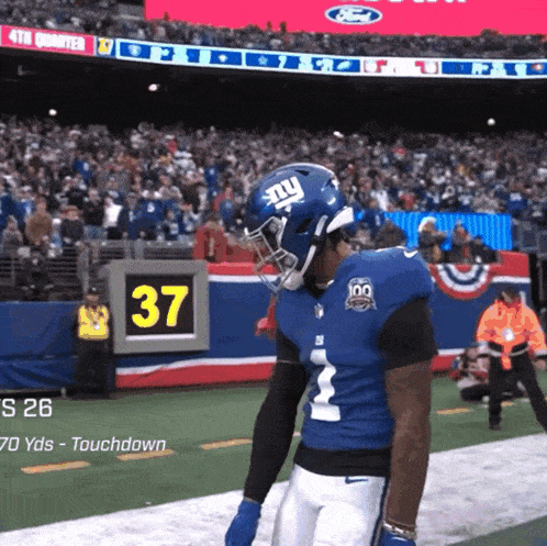 a new york giants player stands on the field