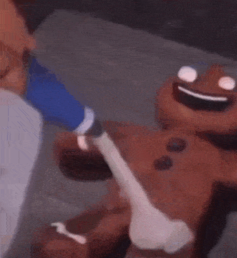 a person is holding a gingerbread man and a light bulb in their hands .