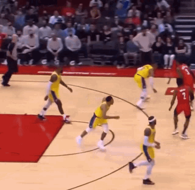 a group of basketball players are on a court and one has the number 2 on his shirt