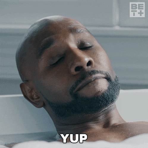 a man laying in a bathtub with the word yup on his face
