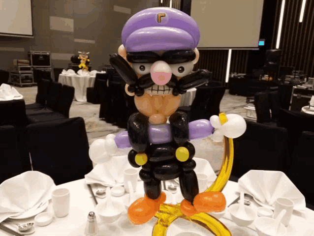 a balloon sculpture of a man with a mustache and a hat with the letter r on it