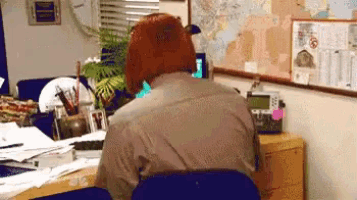 a man wearing a bear costume is sitting at a desk