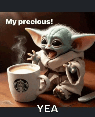 a baby yoda sitting next to a starbucks cup