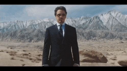 a man in a suit and tie is standing in the desert