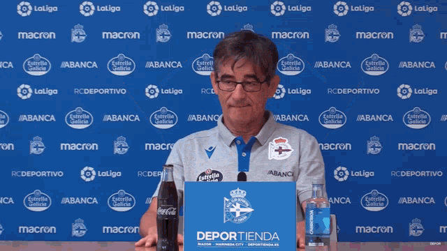 a man stands in front of a blue wall that says laliga on it