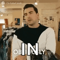 a man is standing in front of a clothes rack in a store .