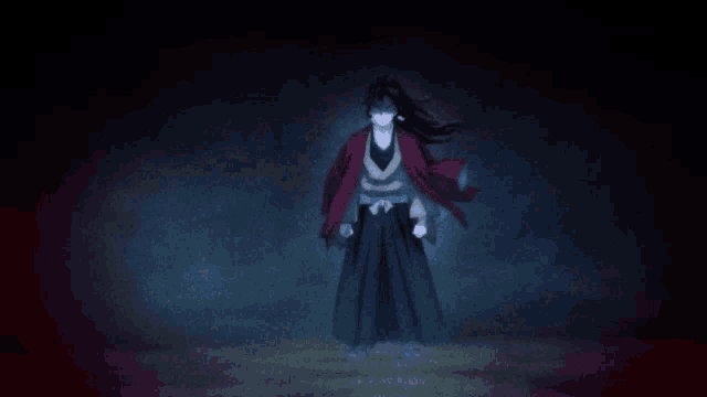 a man in a red jacket and black pants is standing in a dark room