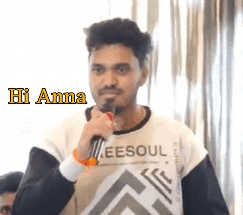 a man wearing a shirt that says ee soul is holding a microphone and says hi anna
