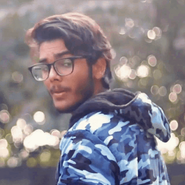 a man wearing glasses and a blue camouflage jacket