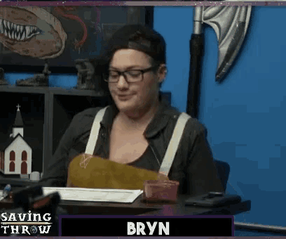 a woman is sitting at a desk with the name bryn on the screen behind her