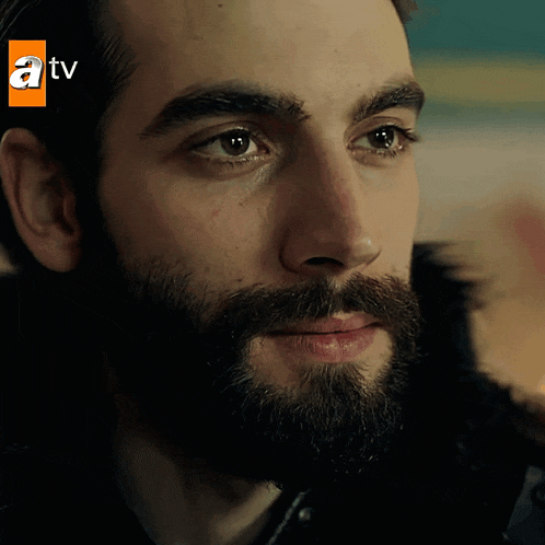 a close up of a man 's face with a tv logo above him